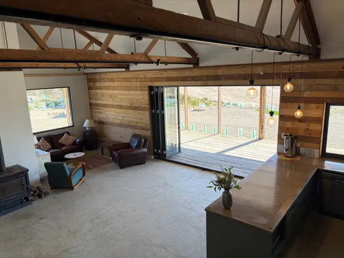 Common room with leather armchairs opening onto the covered deck