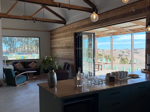 Kitchen looking across to the sitting area, with ocean views through open bifold doors